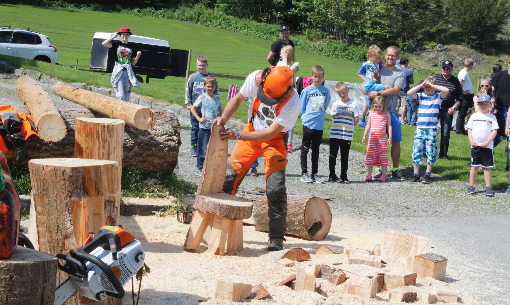 Mange nysgjerrige tilskuere når Per Helle lager stol med motorsag