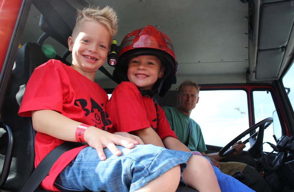 Gutane Adrian Langkås og Krissander Grindhaug fekk sitte framme i brannbilen og køyre rundt i Aksdal ein tur. Foto: Ingvild R. Myklebust