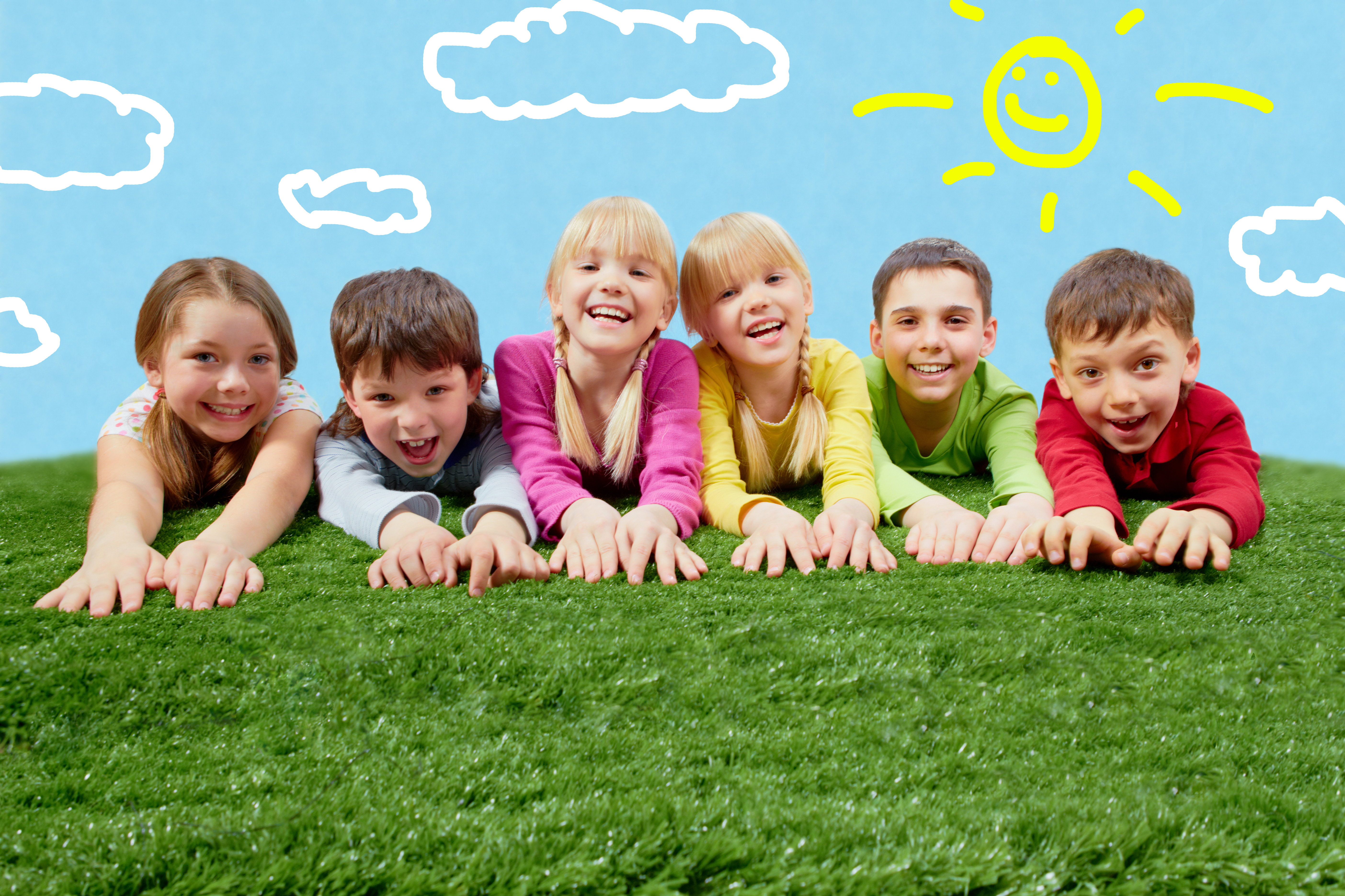 Group of happy children lying on a grass and stretching their hands