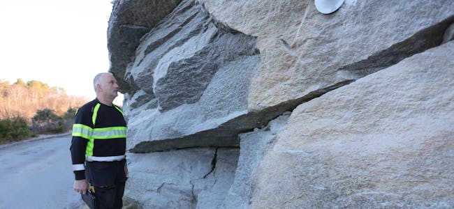 Oddvar Susort viser fram det som også for oss som ikkje har greie på stein er svært dårleg steinmasse med store sprekkar.
Foto: Alf-Einar Kvalavåg