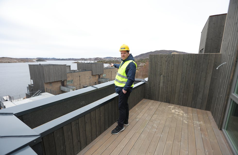 Espen Nordal på terrassen i Skogkanten. Han peiker ned på Vannkanten der det allereie bur folk. Utsikta til Aksdalsvannet og Frakkagjerddalen er upåklageleg.
Foto: Alf-Einar Kvalavåg
