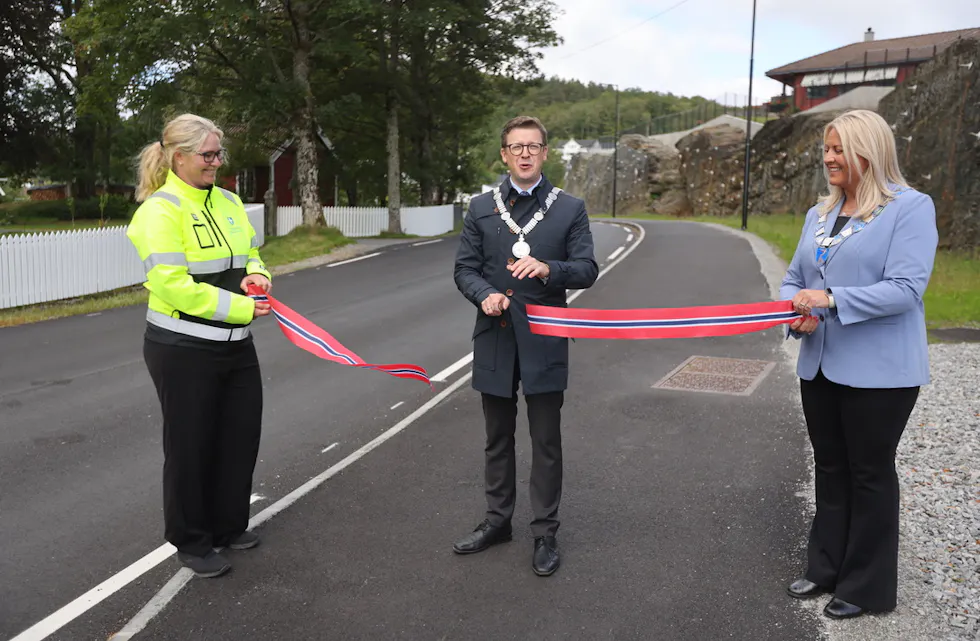 Fylkesordfører Ole Ueland fikk god hjelp til å klippe båndet som markerte åpning av det nye trafikksikringstiltaket På Hinderåvåg. Foto: Alf-Einar Kvalavåg