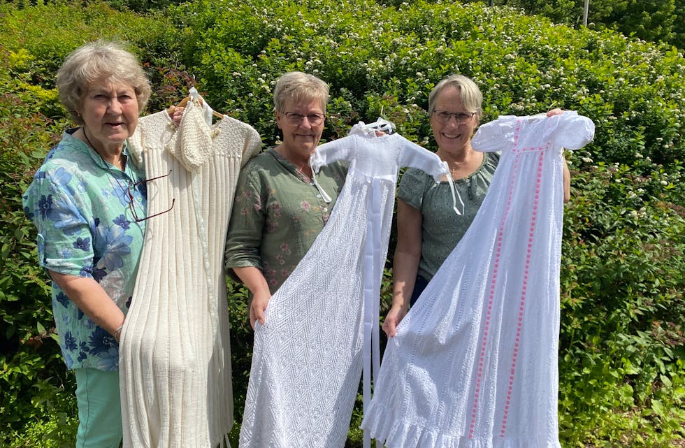 Inger Pedersen-Espevold, leiar i Tysvær Sanitetsforening, og Gerd Borgny Rossebø overleverer tre dåpskjolar til Tysvær sokn v/Marit Sofie Teistedal Vikre (t.h). Kjolane er til gratis utlån for dei som skal døype barna sine.