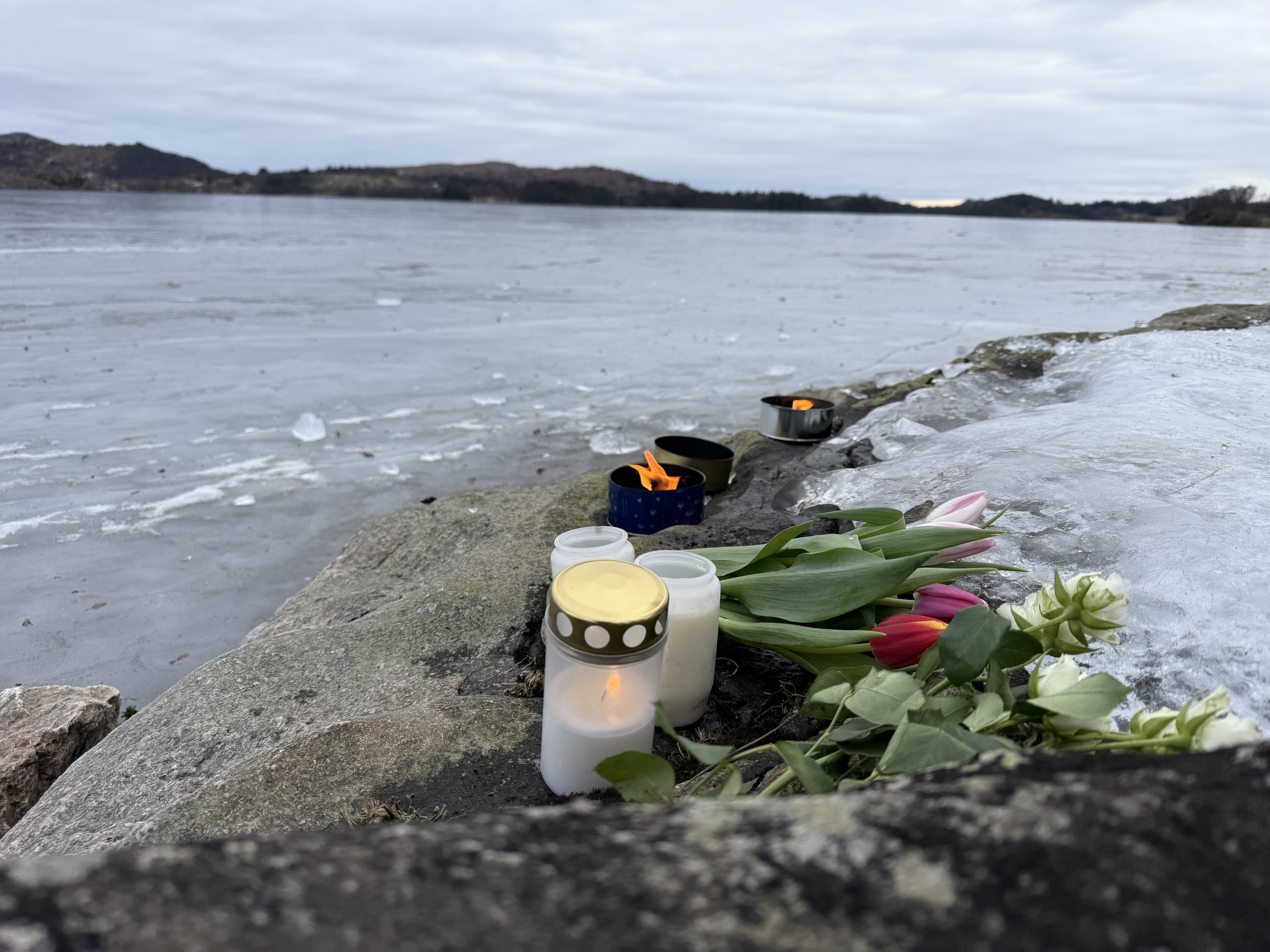 Mandag er det lagt blomster og lys langs vannkanten ved Aksdalsvatnet.