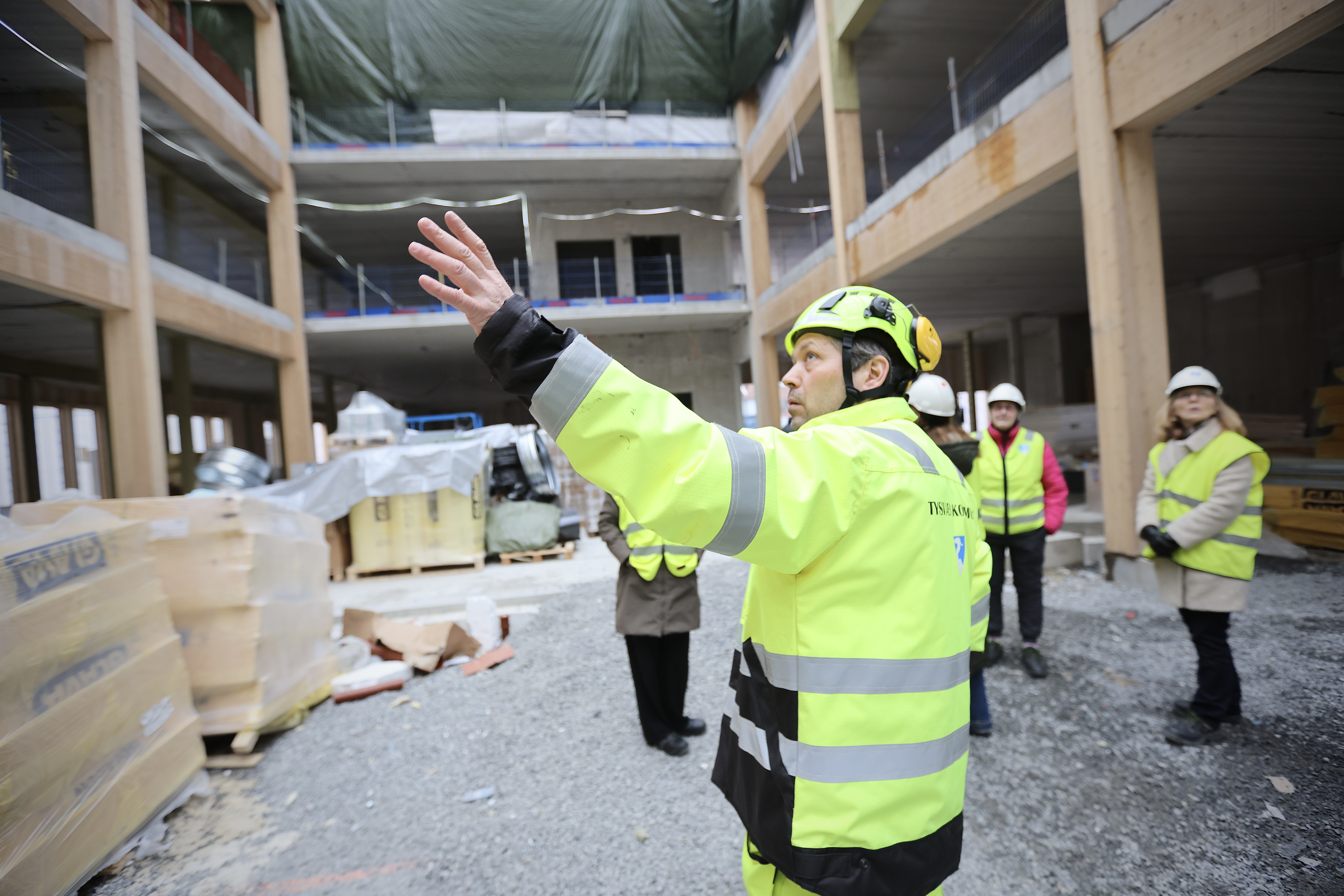 – Nabolaga, som me kallar dei, er plassert i mellombygget, seier Kjetil Gjellestad og peikar i alle retningar. Bak han både helsearbeidarar og politikarar. Foto: Alf-Einar Kvalavåg