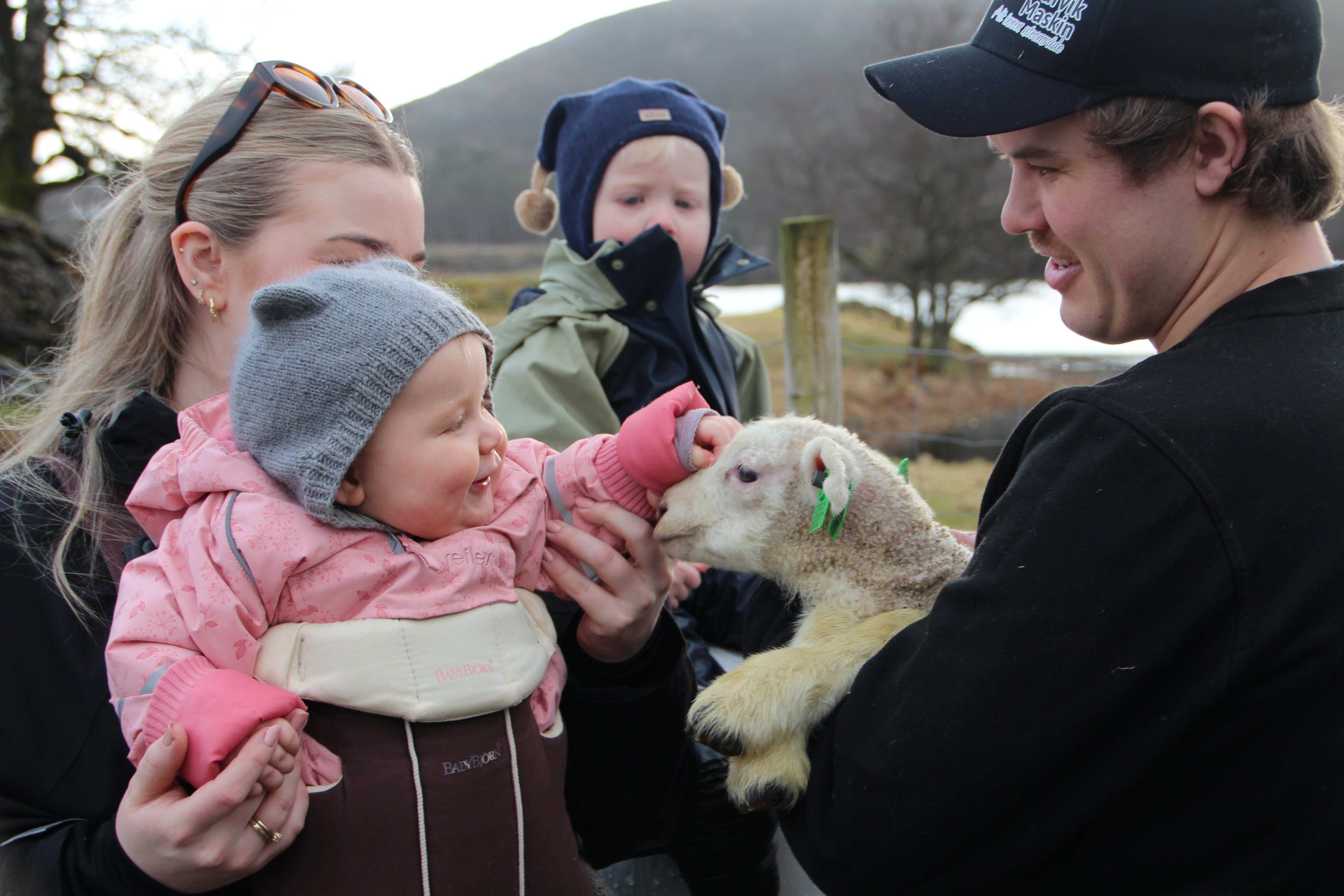 Kornelia (9 mnd) møter et av årets første lam på familiegården i Grinde. Her sammen med mamma, Camilla, broren Berdinius og pappa Tollak Emil.