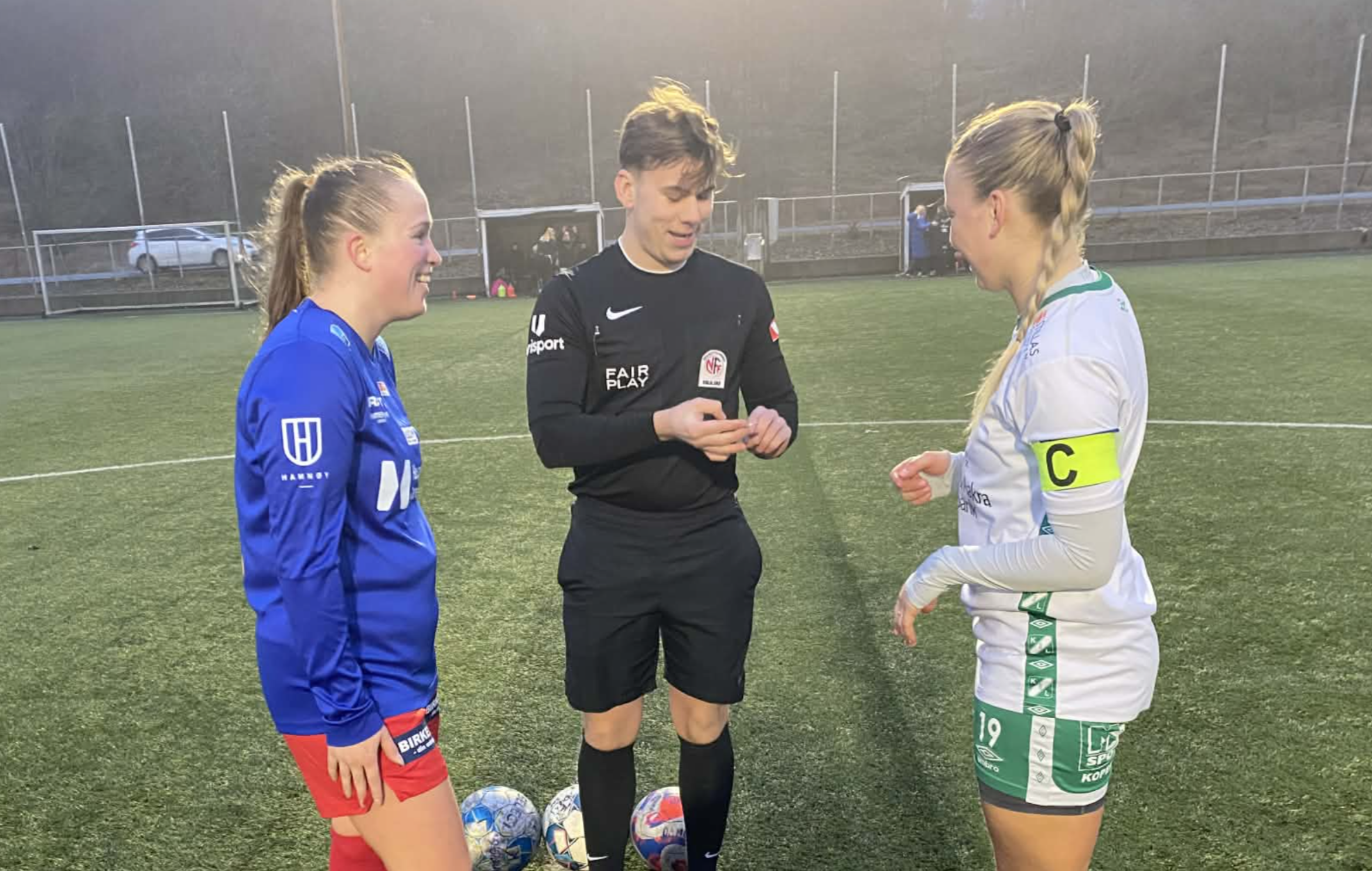 Kapteinene Julie Kaltveit og Martine skår hilser på dommer 
Arne Joseph Hårde-Keogh. Foto: Asbjørn Bakken