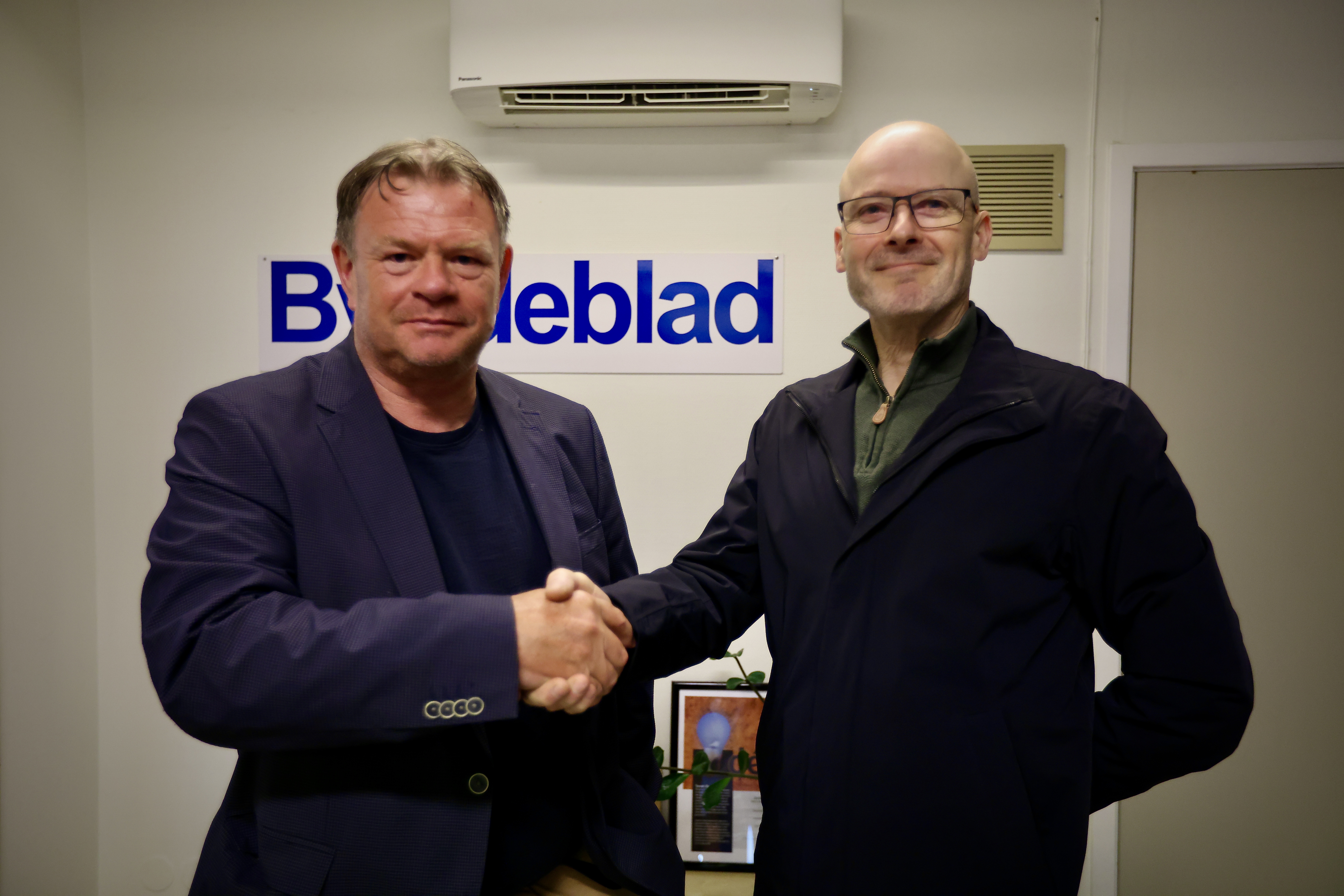 Dagens redaktør Alf-Einar Kvalavåg får et solid håndtrykk av styreleder Einar Magne Storhaug. Redaktøren er nå inne i sitt siste år i lokalavisen.