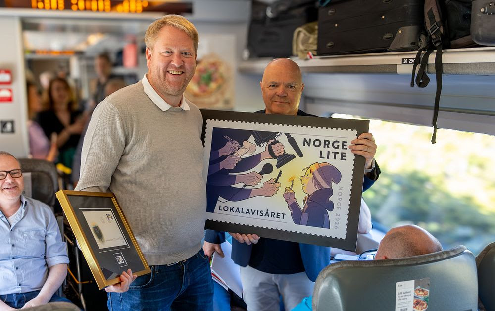 Styreleder i Landslaget for lokalaviser (LLA), Øystein Øygarden og frimerkedirektør Roar Toresen i Posten Bring avduket det nye frimerket på Lokalavistoget torsdag.