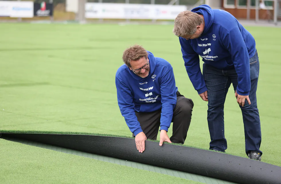 Rune Waage og Øystein Odland sjekkar at alt er på plass før ein limer kunstgraset saman.